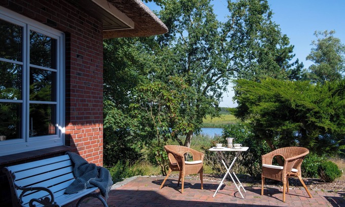 Breiholz House | Right on the water: large thatched-roof house for 8 people with garden and fireplace